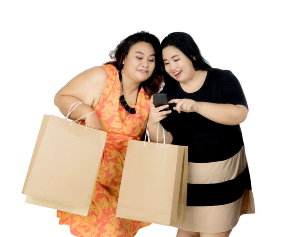 Two women holding shopping bags while looking at a smartphone for AlphaGenics medical weight loss program inspiration